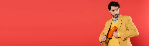 Modèle tendance cachant haut-parleur près de veste isolé sur rouge, bannière — Photo de stock