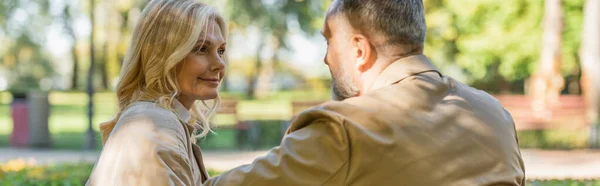 Mature couple talking while spending time in spring park, banner — Stock Photo