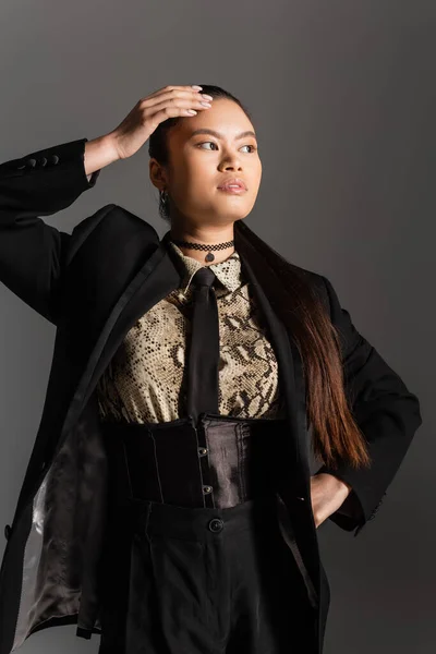 Trendiges asiatisches Model in Jacke und Hemd mit Animal Print posiert isoliert auf grau — Stockfoto