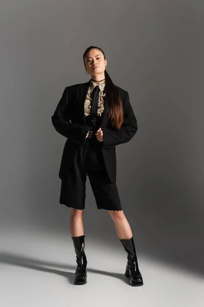 Moda modelo asiático em jaqueta e shorts de pé sobre fundo cinza — Fotografia de Stock