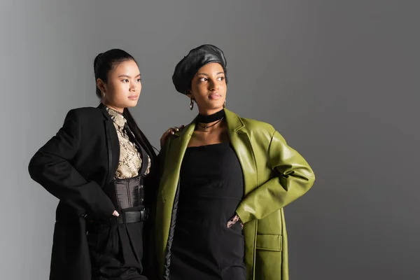 Modelos inter-raciais na moda em roupas de primavera posando e olhando para longe isolado em cinza — Fotografia de Stock