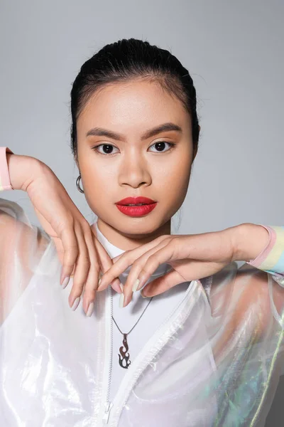 Ritratto di modella asiatica ben vestita con labbra rosse in posa su sfondo grigio — Foto stock
