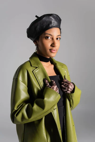 Porträt einer afrikanisch-amerikanischen Frau in Tiermusterhandschuhen und stylischem Ledermantel isoliert auf grau — Stockfoto