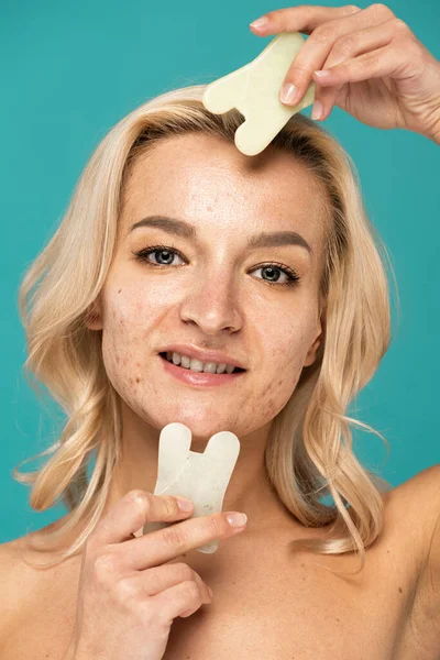 Fröhliche Frau mit Makeln mit Gesichtsschaber isoliert auf Türkis — Stockfoto