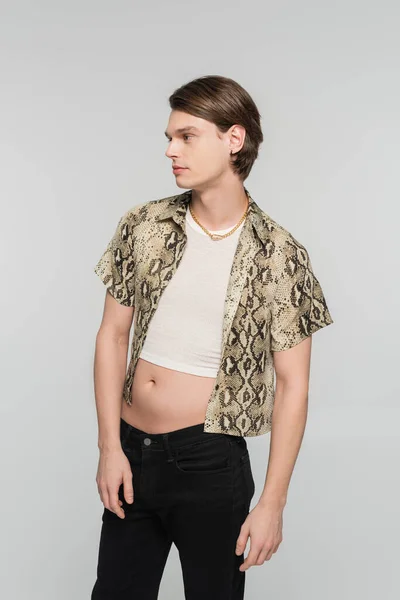 Junge und trendige Pangender-Person in Crop Top und Animal-Print-Bluse, die vereinzelt auf Grau wegschaut — Stockfoto