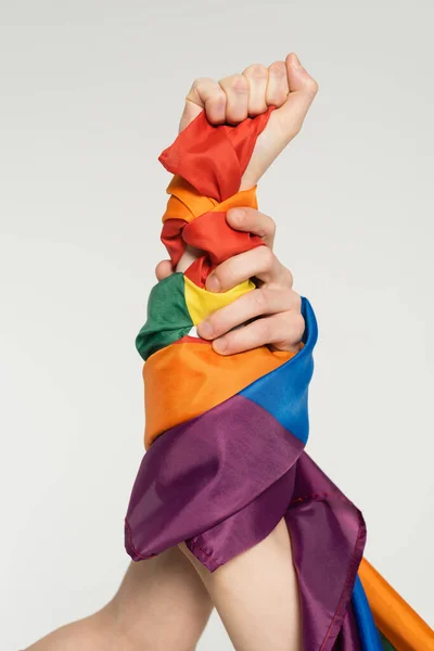 Partial view of hands of nonbinary couple with lgbt flag isolated on grey — Stock Photo
