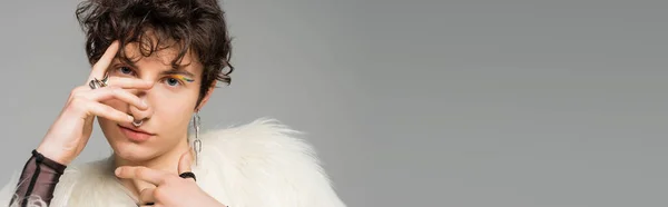 Retrato de pessoa bigender elegante em branco casaco de pele falso cobrindo rosto com a mão isolada em cinza, banner — Fotografia de Stock