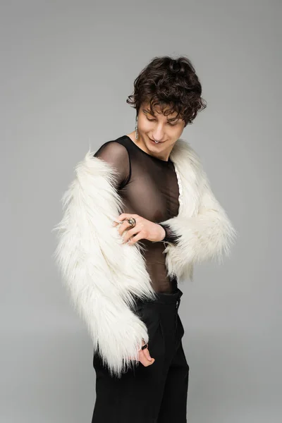 Brunette nonbinary person wearing white faux fur jacket isolated on grey — Stock Photo