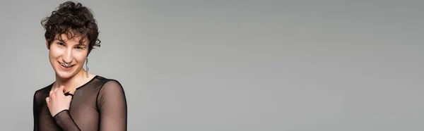 Persona pangender sorridente in posa in top nero trasparente isolato su grigio, banner — Foto stock