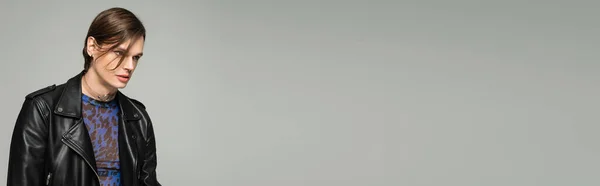 Pessoa bigender confiante em animal imprimir top e jaqueta de couro preto olhando para longe isolado em cinza, banner — Fotografia de Stock