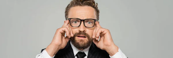 Homme d'affaires stressé en tenue formelle et lunettes regardant la caméra isolée sur gris, bannière — Photo de stock
