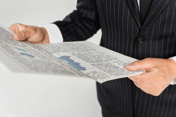 Vista recortada del empresario sosteniendo periódico aislado en gris - foto de stock