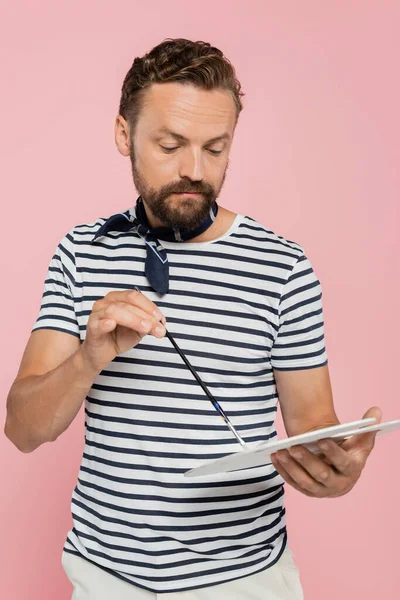 Artiste français barbu avec écharpe au cou tenant palette et pinceau isolé sur rose — Photo de stock
