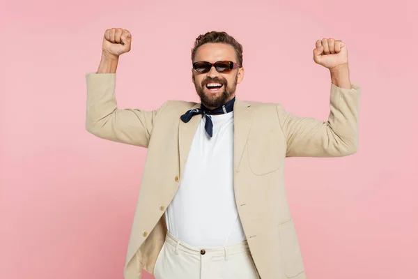 Excited french guy in neck scarf and stylish sunglasses standing isolated on pink — Stock Photo