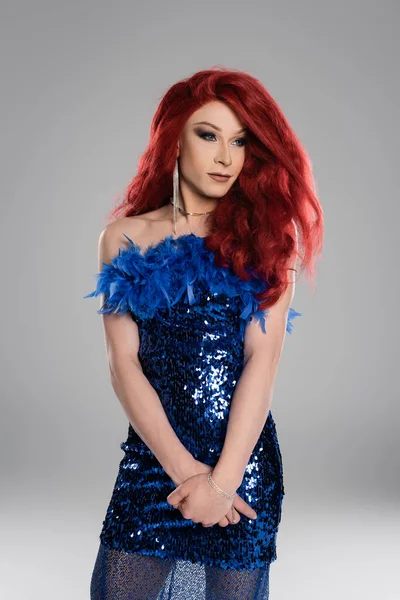 Elegante drag queen en peluca roja y vestido de pie aislado en gris - foto de stock