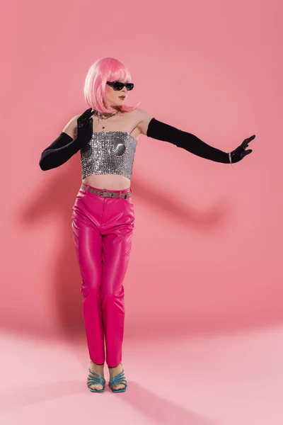 Full length of drag queen in sparkling top and gloves posing on pink background — Stock Photo