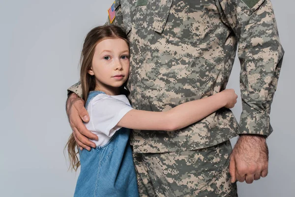Preteen fille câlin courageux père en uniforme pendant jour commémoratif isolé sur gris — Photo de stock