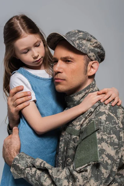 Sad girl hugging serviceman in military uniform crying during memorial day isolated on grey — Stock Photo