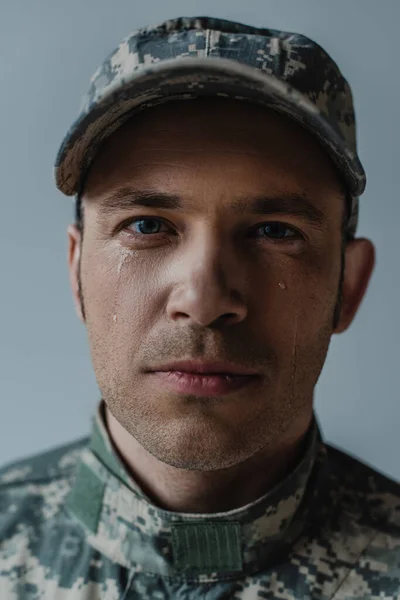 Porträt eines traurigen Soldaten in Militäruniform, der am Gedenktag weint, isoliert auf grau — Stockfoto