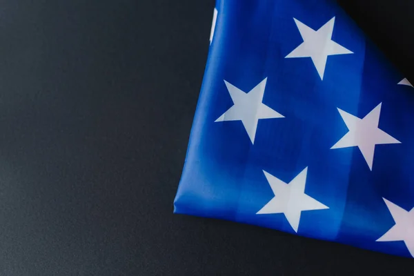 Draufsicht der gefalteten Flagge der Vereinigten Staaten in Dreiecksform während des Gedenktages isoliert auf schwarz — Stockfoto