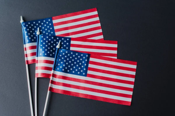 Vista dall'alto di tre bandiere d'America con stelle e strisce isolate sul nero — Foto stock