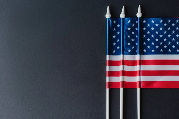 Tendido plano de tres banderas de América con estrellas y rayas aisladas en negro - foto de stock