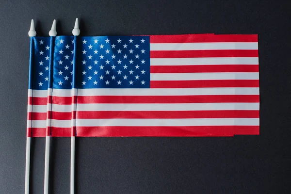 Tendido plano de tres banderas americanas con estrellas y rayas aisladas en negro - foto de stock