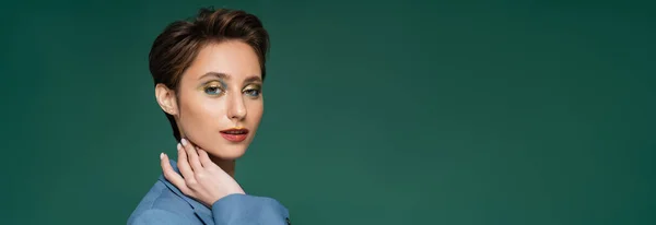 Pretty young woman with short hair posing in blue blazer on turquoise green background, banner — Stock Photo