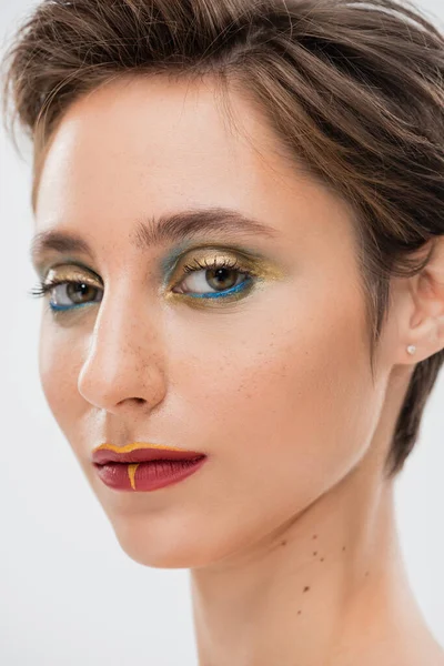 Close up view of young model with bright makeup looking at camera isolated on grey — Stock Photo