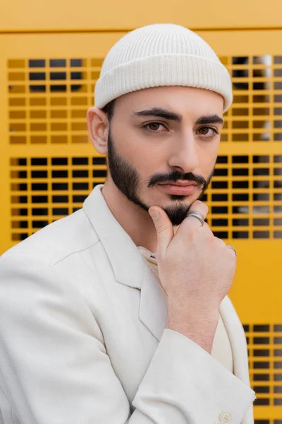 Retrato de elegante gay homem no bege chapéu olhando para câmera ao ar livre — Fotografia de Stock