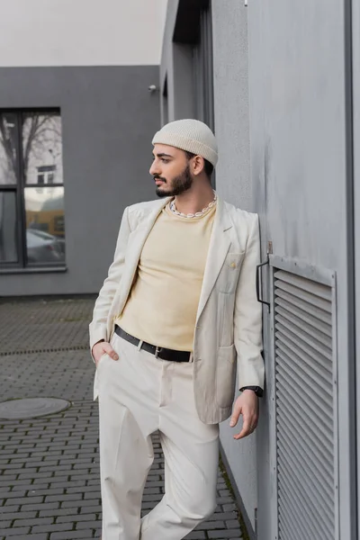 Bem vestido gay homem no bege jaqueta posando perto de edifício ao ar livre — Fotografia de Stock