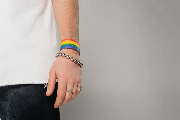Ausgeschnittene Ansicht eines homosexuellen Mannes mit lgbt Armband an der Hand, der isoliert auf grau steht — Stockfoto
