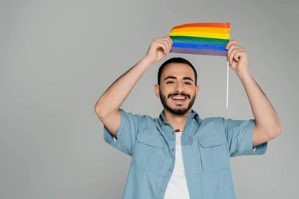 Uomo omosessuale positivo con bandiera lgbt isolata su grigio con spazio su copia, Giornata internazionale contro l'omofobia — Foto stock