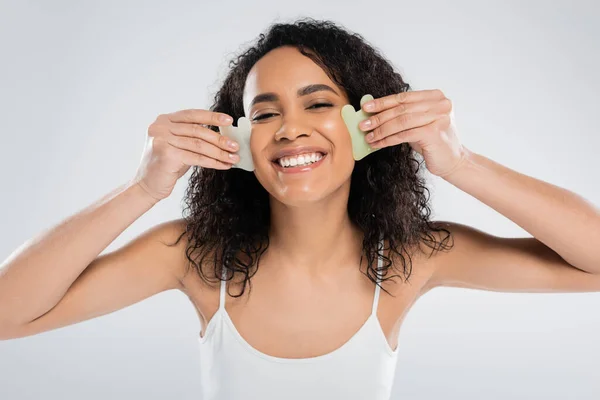 Morena afro-americana usando raspadores de rosto isolados em cinza — Fotografia de Stock