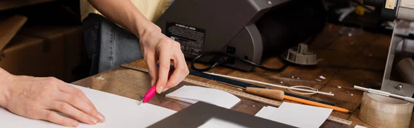 Cropped view of typographer cutting paper with knife in print center, banner — Stock Photo