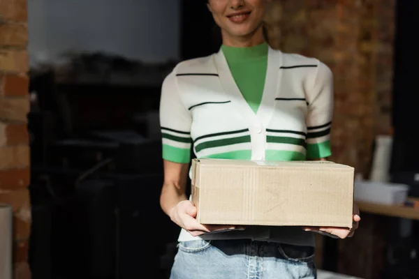 Cropped view of cheerful publisher holding carton box in modern print center — Stock Photo