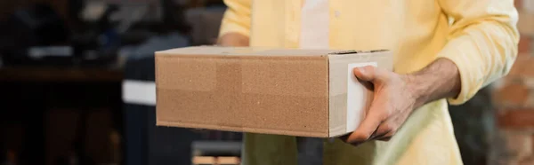 Cropped view of publisher holding carton box in print center, banner — Stock Photo