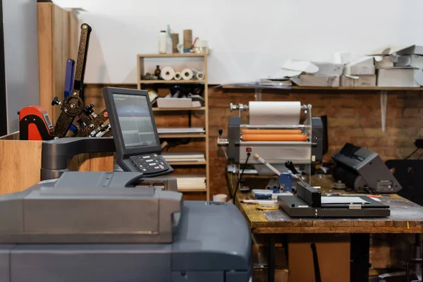 Современное оборудование печатного центра рядом с монитором и триммером для бумаги — стоковое фото