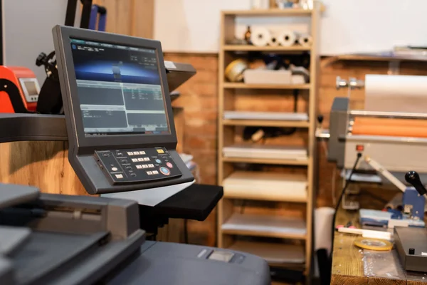 Impressora moderna ao lado do monitor e painel de botões no centro de impressão — Fotografia de Stock