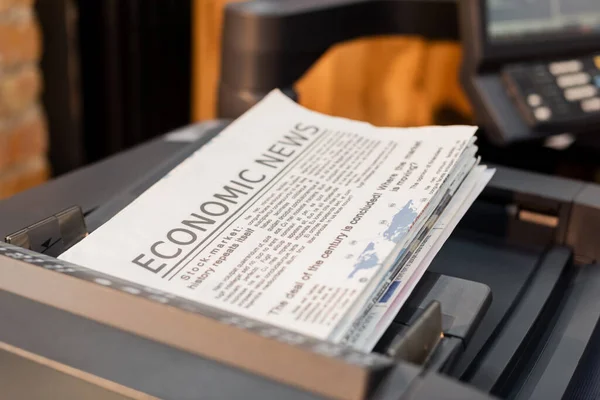Freshly printed newspapers with economic news inside of professional printer — Stock Photo