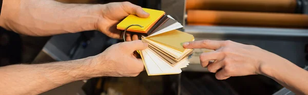 Partial view of typographer pointing at color samples in print center, banner — Stock Photo