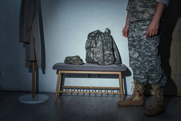 Vue en coupe du vétéran militaire debout dans le couloir à la maison la nuit — Photo de stock