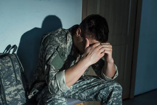 Veterano militar solitário com transtorno de estresse pós-traumático sentado no corredor em casa à noite — Fotografia de Stock
