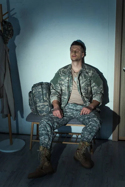 Einsamer Militärveteran mit posttraumatischer Belastungsstörung sitzt nachts im Hausflur — Stockfoto