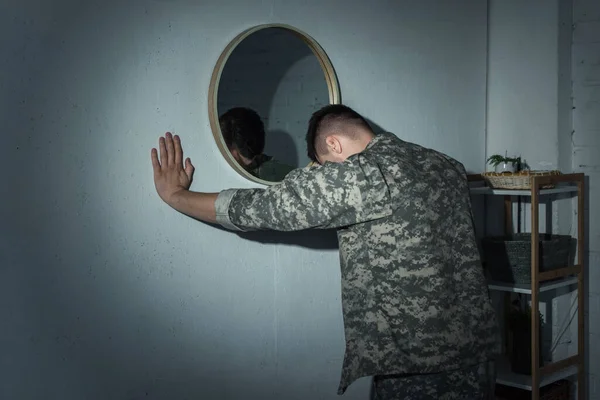 Ветеран войны с психическими заболеваниями ночью стоит у зеркала дома — стоковое фото