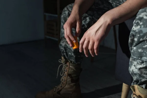 Cropped view of military veteran with ptsd holding pills at home at night — Stock Photo