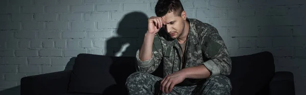 Depressiver Soldat in Uniform, der unter ptsd leidet und nachts auf dem Sofa sitzt, Banner — Stockfoto