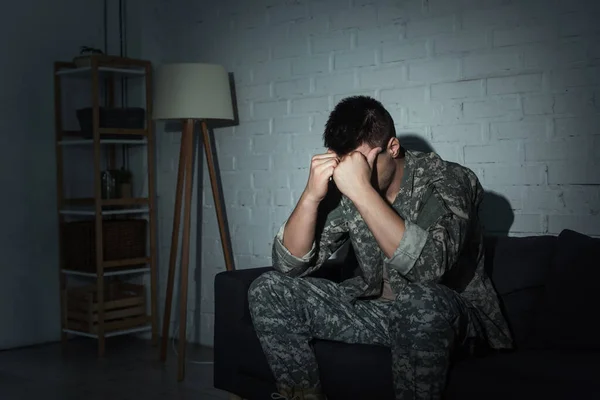 Military veteran in uniform suffering from emotional distress at home at night — Stock Photo