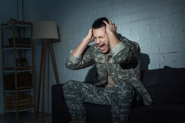 Роздратований військовий ветеран кричить, страждаючи від емоційного лиха вдома вночі — стокове фото