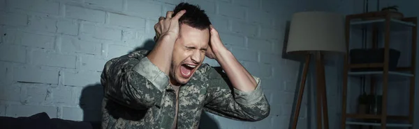 Злой солдат с психическим расстройством кричит дома по ночам, баннер — стоковое фото